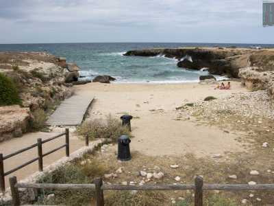 ...ma ci basta percorrere qualche passo per ritrovare finalmente la sabbia. Siamo a �Cala Monaci�, una spiaggia che si insinua fra due alti costoni rocciosi e alla quale � possibile accedere grazie a una passerella